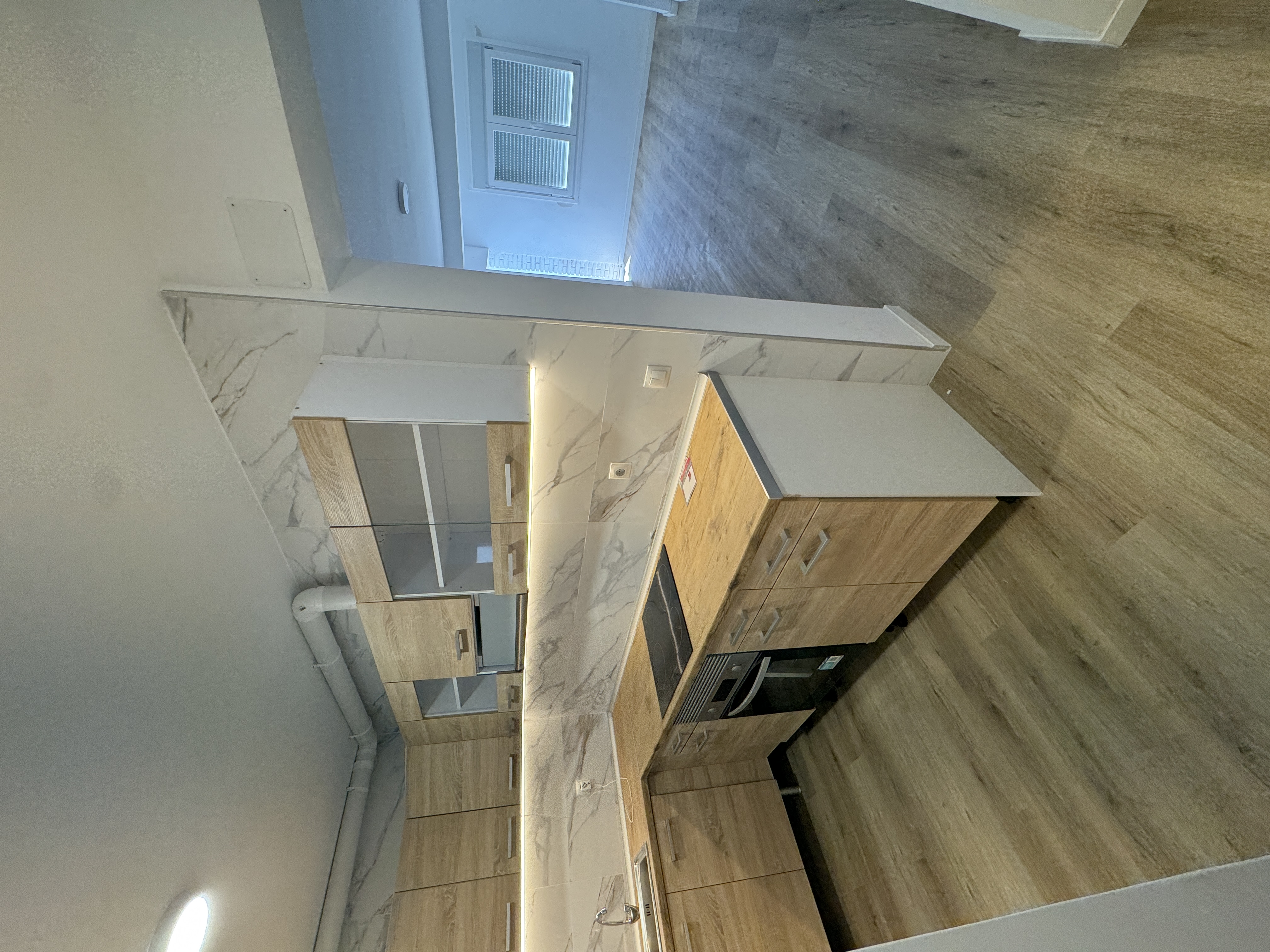 Cocina con muebles de madera abierta hacia el salón