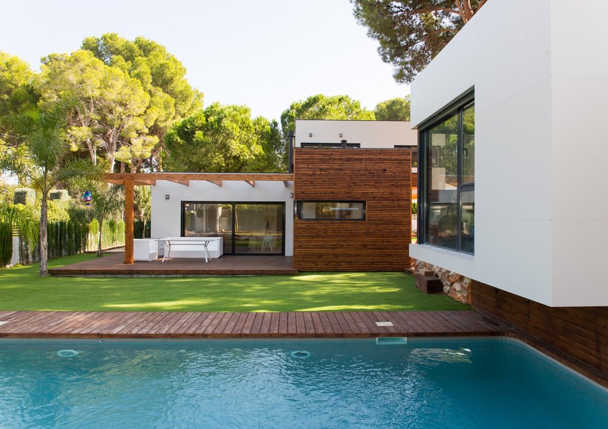 Vivienda de referencia en Dénia con jardín, piscina y volúmenes de madera y fachada blanca